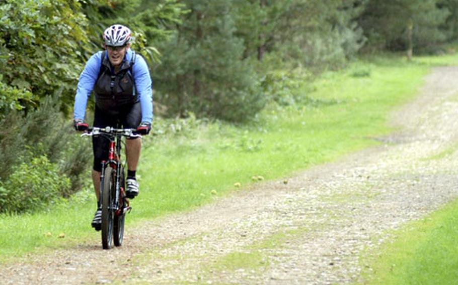 A bicyclist enjoys a morning ride along a path near the High Lodge inside the Thetford Forest.