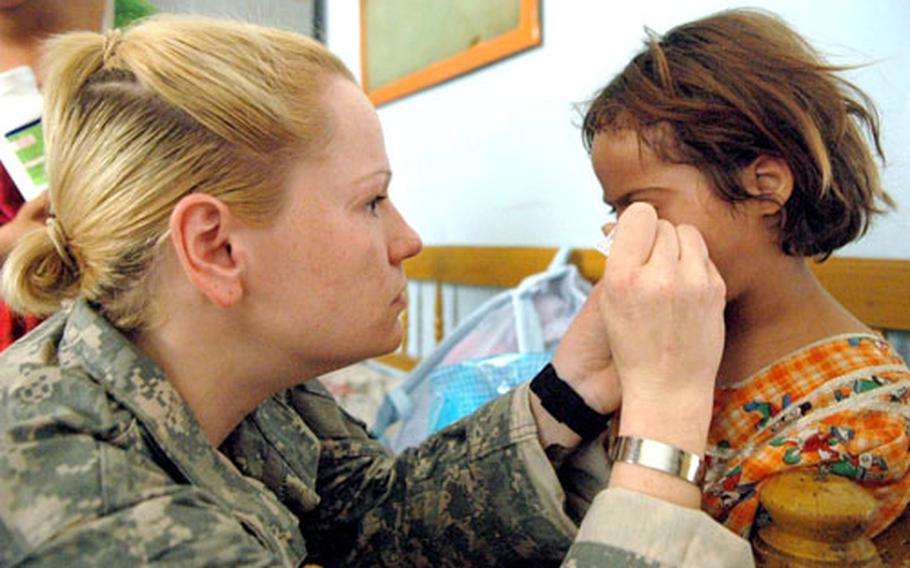 Sgt. Katie Faint examined a little girl's eye during a recent medical operation in Baghdad.
