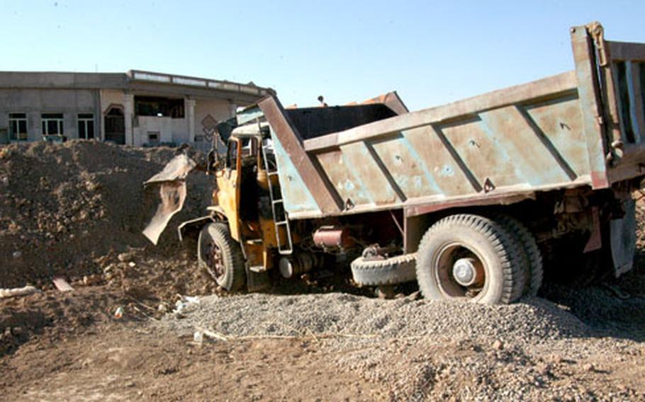The dump truck insurgents used in a bombing attempt on Battle Position 1 near Hawijah, Iraq, sits next to the berm where soldiers stopped it Sept. 28.