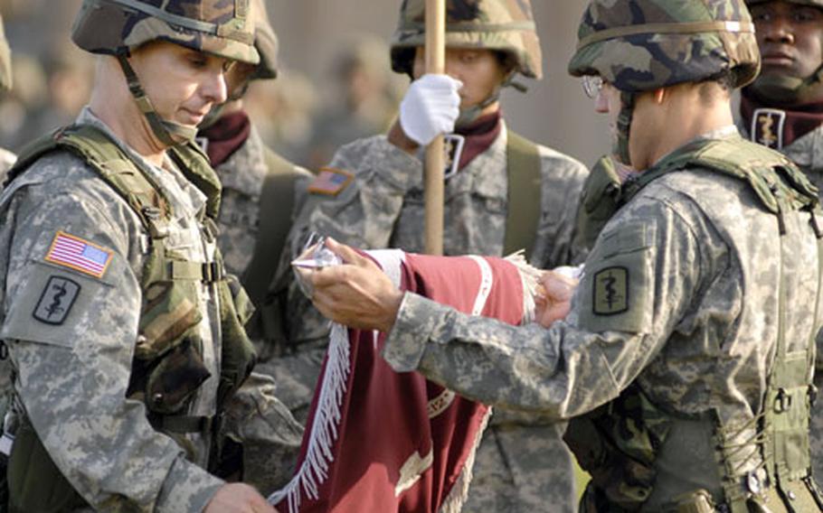Command Sgt. Maj. Michael Mendoza, left, and Col. Angel L. Lugo, commander of the 212th Mobile Army Surgical Hospital, case the flag of the Army’s last MASH unit during a ceremony Monday commemorating the official conversion to Combat Support Hospital. Lugo remains commander of the new unit.