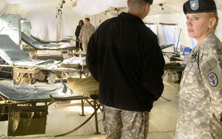 Lt. Col. Karrie Fristoe, commander of the health clinic at Hanau, Germany, takes a tour of the 212th Combat Support Hospital’s intensive care tent Monday. Fristoe, whose first assignment was to a MASH unit, says that the new Combat Support Hospital will bring the benefits of a fixed hospital to the battlefield.