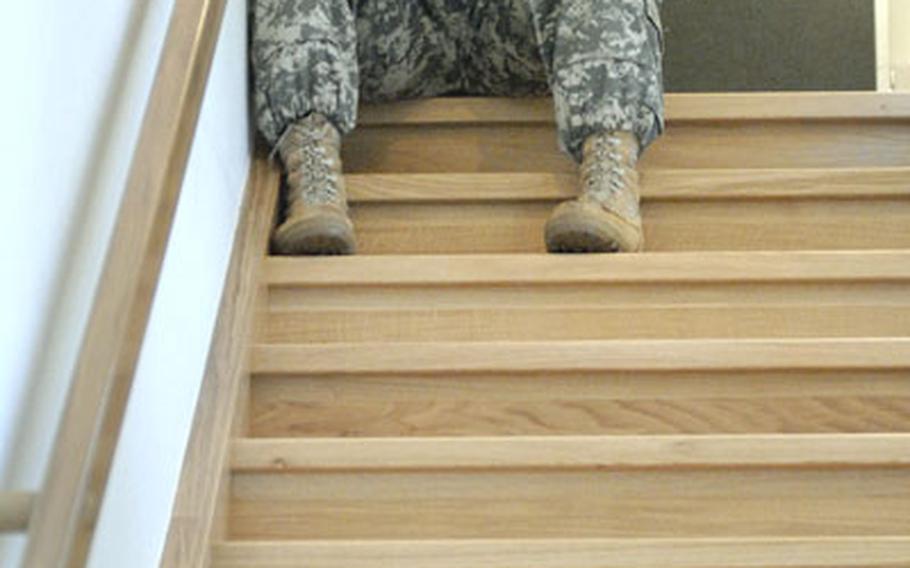 A soldier at the rear of the Baumholder chapel reflects upon the loss of Staff Sgt. Jose A. Lanzarin and Pfc. Shane R. Austin during a memorial ceremony Thursday. Lanzarin and Austin were killed during combat patrols almost a week apart in Ramadi, Iraq.