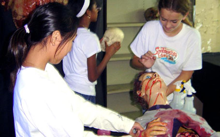 Zama American High School students (left to right) Jennie Rice, Annette Thomas and Maggie Swift help prepare the "butcher shop" as part of the Zama Youth Center "Die N Theater" haunted house running later this month at Camp Zama, Japan.