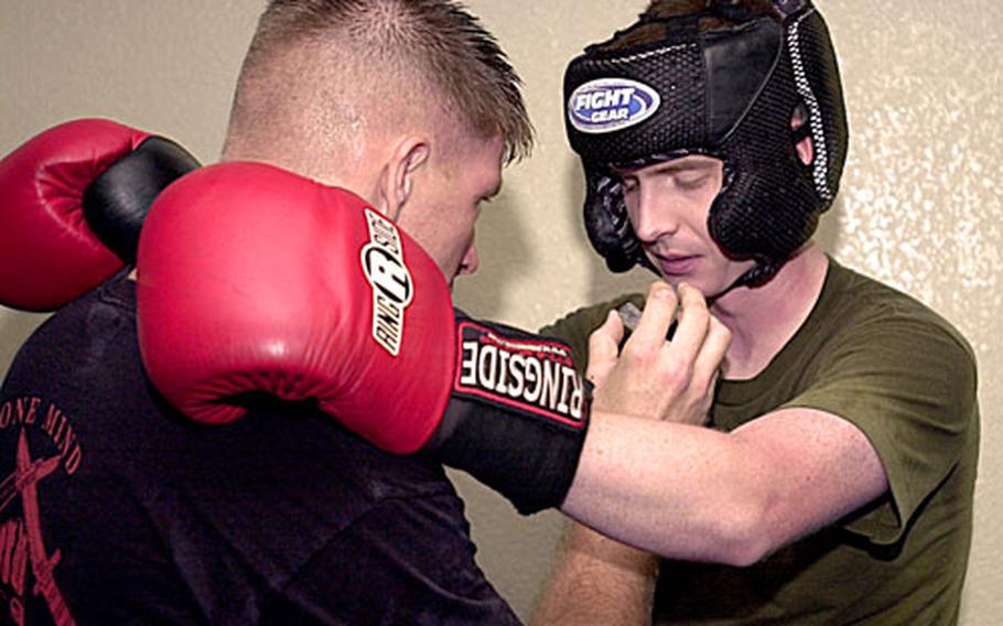 Sgt. Paul Rozsa, left, 23, an instructor-trainer, makes sure Cpl. Brandon J. Nierhoff, 22, a student, is OK to continue sparring during a combat conditioning exercise on training day three for Class 1-07 of the Marine Corps Martial Arts Instructors Course at Camp Courtney, Okinawa. Nierhoff graduated from the course Friday.