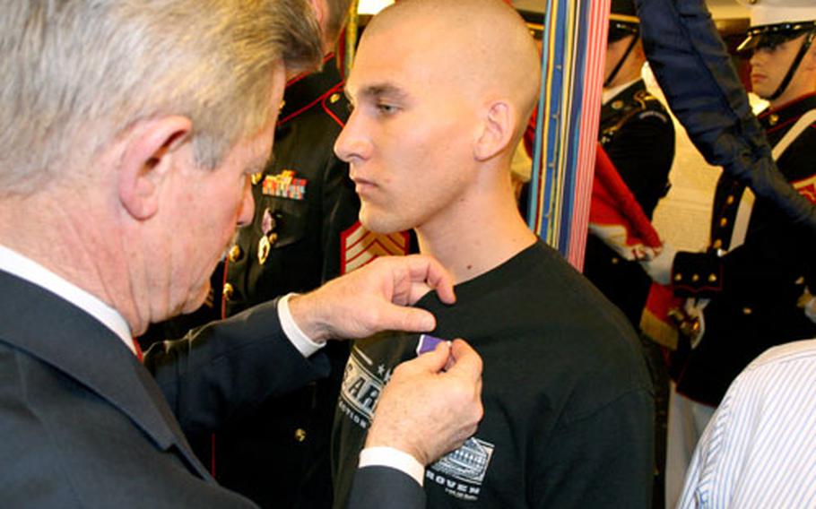 Secretary of Veterans Affairs R. James Nicholson pins a Purple Heart on Army Spc. Nicholas Helfferich of the 1st Battalion, 37th Armor, 1st Armored Division during a Wednesday ceremony in Washington.