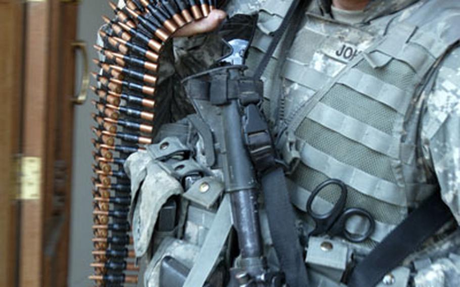 Sgt. Robin Johnson, from Scout Platoon, Company C, 1st Battalion, 26th Infantry Regiment, hauls out belts of 7.62-mm machine-gun rounds found in a house in northern Ahdamiyah on Wednesday.