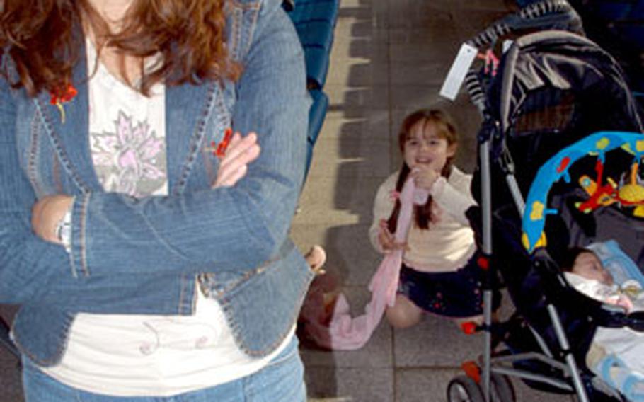 Yanira Gonzales and daughters Amber, 4, and Rubi, 2 months, wait Friday for a flight at the Ramstein passenger terminal.