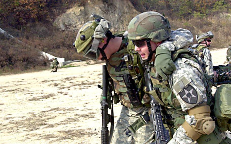 A 2nd Combat Aviation Brigade soldier helps a “wounded” comrade Friday at Rodriguez Range during preparation for a live-fire exercise.