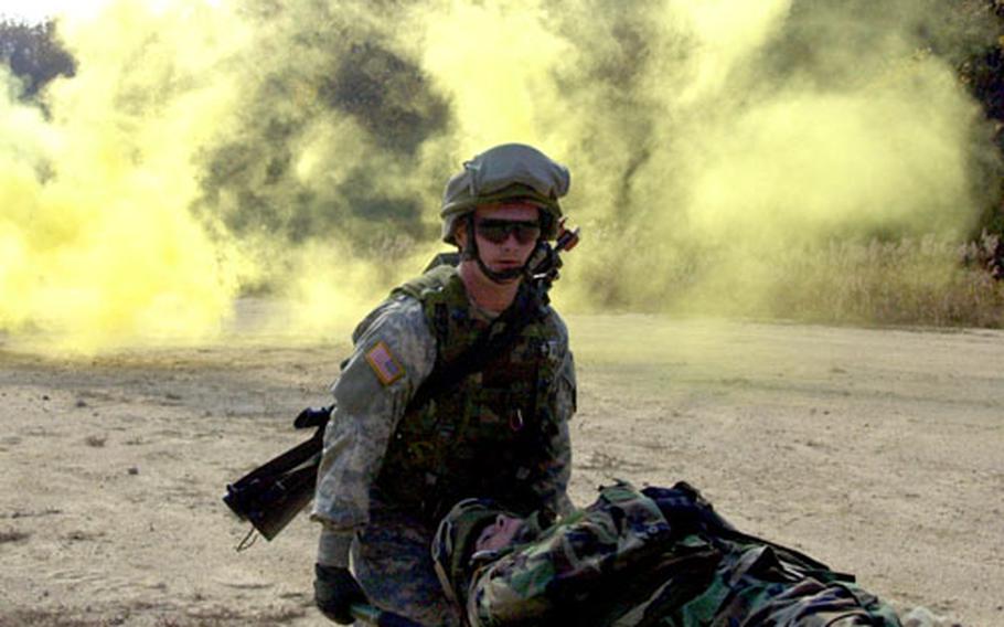 A 2nd Combat Aviation Brigade soldier helps a “wounded” comrade Friday at Rodriguez Range in preparation for a live-fire exercise.
