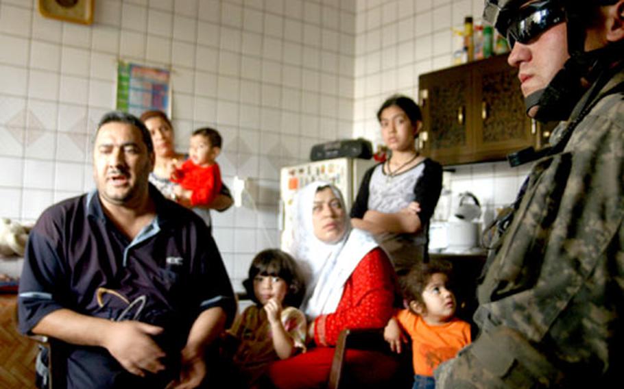 Sgt. Matthew Campbell, 23, from Seattle, listens to a Baghdad resident talk about his concerns in the Tunis neighborhood Sunday, where members of Company B, 1st Battalion, 26th Infantry Regiment were on patrol while the Hussein verdict was being read.