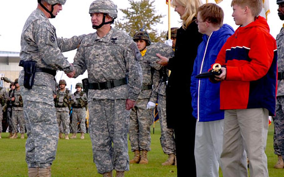 Gen. David D. McKiernan, U.S. Army Europe’s commanding general, left, promotes David R. Hogg, the 1st Armored Division’s Assistant Division Commander for Support, to brigadier general at Wiesbaden Army Airfield last week. Hogg’s wife Martina and sons Bryan and Aaron complete the promotion by handing him his one-star Kevlar.