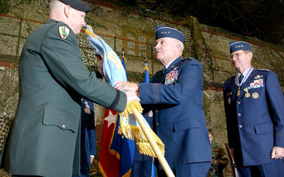 Army Gen. B.B. Bell, left, commander of U.S. Forces Korea, hands the Air Component Command flag to Air Force Lt. Gen. Stephen G. Wood, who took command of the unit and U.S. 7th Air Force during a ceremony at Osan Air Base on Monday. Wood replaced Lt. Gen. Garry R. Trexler, right, who headed both units since November 2003.