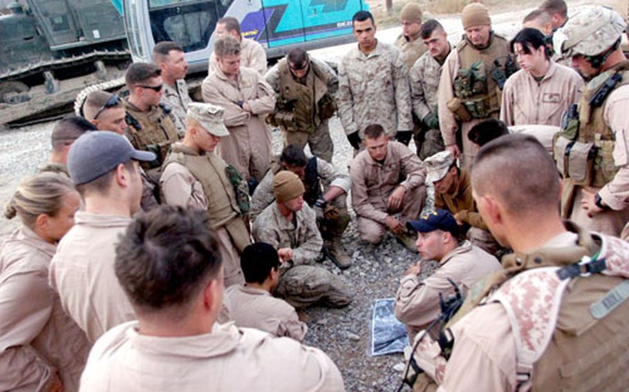 First Lt. Joe Apkarian, center, goes over the day’s plan on Monday with a route-clearance team from Company B, 9th Engineer Support Battalion at an Iraqi army base in Jazeriah, Iraq, in Anbar province. The group removed and destroyed 15 bombs over seven days along a stretch of road outside the base.