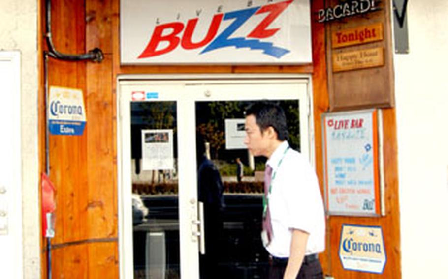 A man walks by Live Bar Buzz Tuesday where a 70-year old Japanese man sustained injuries last Thursday night. The man died in a Yokosuka hospital Tuesday and a U.S. Navy civilian is in Japanese police custody as a suspect.