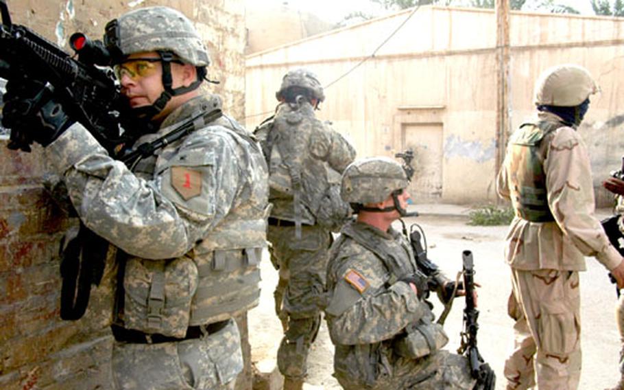 Staff Sgt. Jeremy Rausch, left, covers an alley in Adhamiyah while soldiers look for two men who fled from U.S. forces recently in this violent Sunni neighborhood in northeast Baghdad. U.S. troops keep a tight schedule of patrols through the area looking for suspicious activitiy. They often find bodies.
