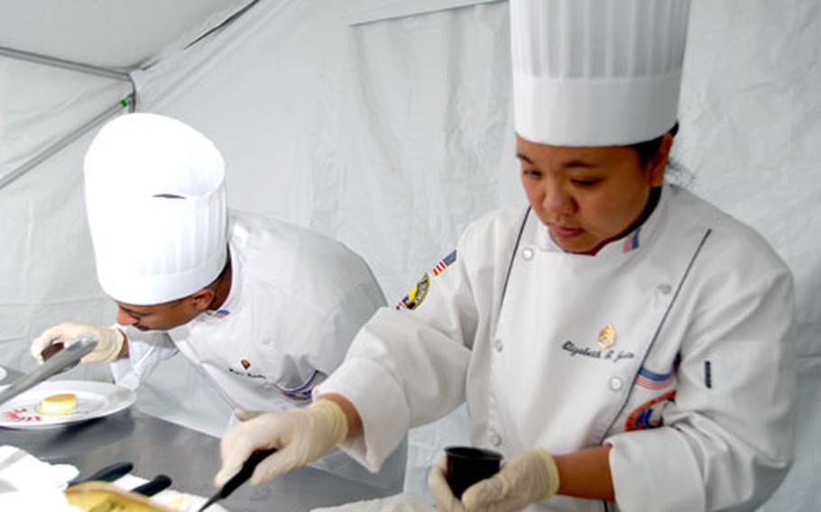 Spc. Wayne Daren, 27, of Washington, D.C., left, and Staff Sgt. Elizabeth Justa, 36, of Lawton Okla., make desserts at Camp Aachen in Grafenwöhr, Germany, on Wednesday.