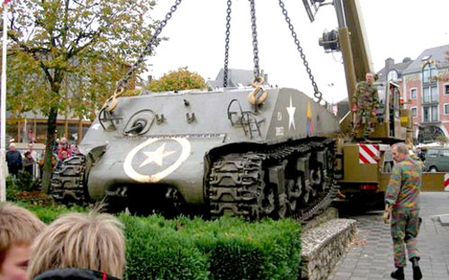 Belgian workman prepare to lift a partially disassembled Sherman tank from its site in Bastogne, Belgium, so it can be taken to a nearby Belgian military base for a six-month refurbishment. The tank was used by the U.S. in World War II.
