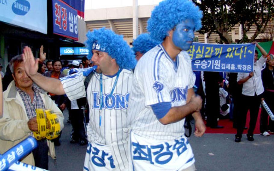 Jeff Mondella, left, and Kenny Lamothe dance last month in support of the Samsung Lions in Daegu, South Korea. Both are civilian contractors working for the U.S. military at Camp Walker.