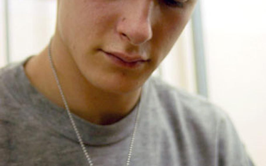 Pvt. Shane Hornbeck, 20, from Carrollton, Ky., looks at the bullet fired at him while he was getting into his Humvee in Baghdad. The round struck Hornbeck’s side protection plate, and he now wears it around his neck.