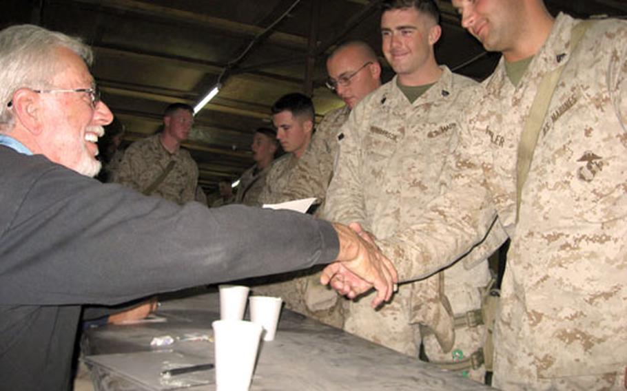 John J. McGinty III, left, a retired Marine and one of 111 living Medal of Honor winners, greets troops during a visit to Camp Taqaddum in Anbar province, Iraq.