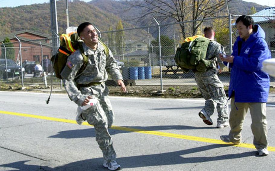 Sgt. Luciano Vera charges across the finish line outside Carey Gym during the 8 Mile Rucksack Challenge at Camp Casey, South Korea, on Saturday. About 80 soldiers competed in the event, with 2nd Lt. Michael Woudenberg finishing first in 58:12.