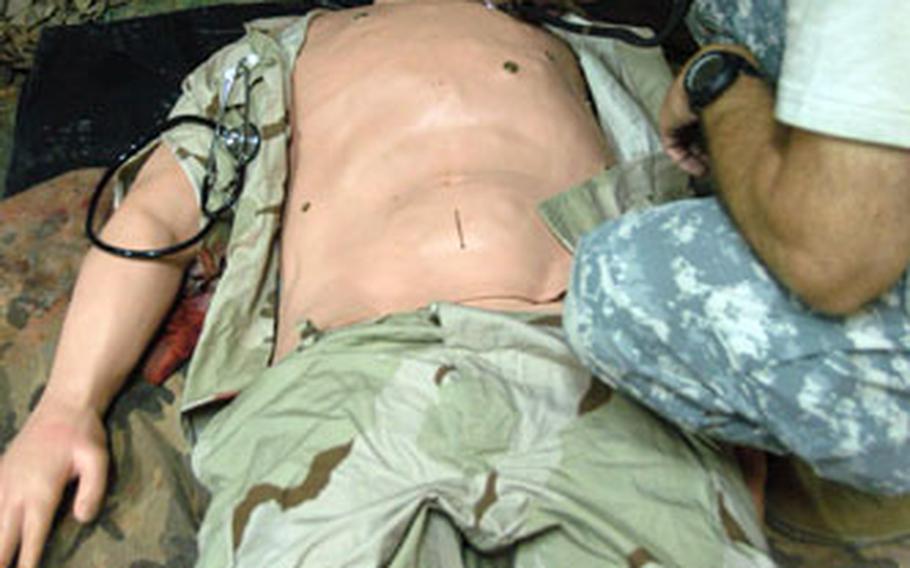 Staff Sgt. Michael Grabowski from the 3rd Medical Command at Logistics Support Area Anaconda, Balad, listens to the METI-man (aka Lt. Dan) breathe at the Jameson Combat Care Center in Balad, Iraq.