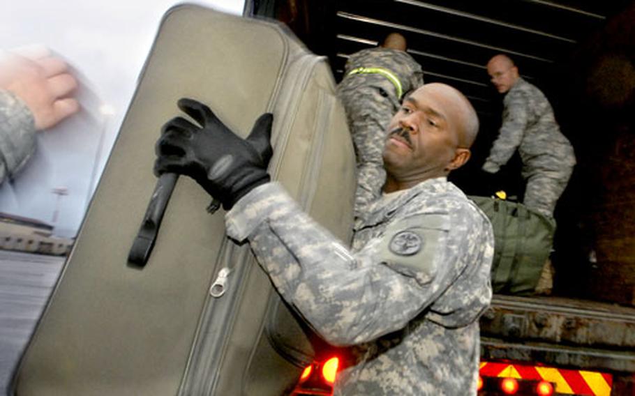 Staff Sgt. Franklyn Harper, a training noncommissioned officer with Company B at Landstuhl Regional Medical Center in Germany, lends a hand Tuesday to Naval reservists arriving at Ramstein Air Base.