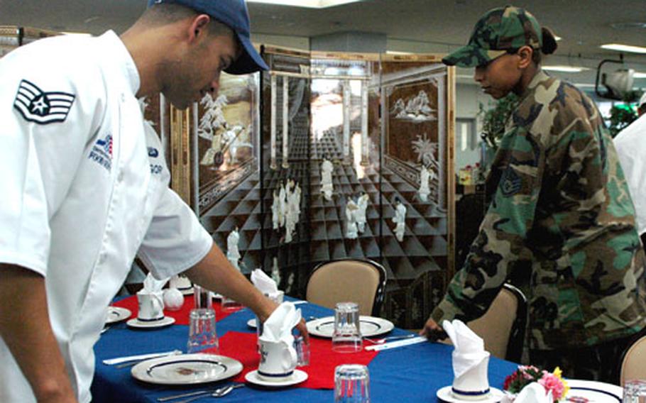Staff Sgts. Tyrone Gregory, left, and Angola Wellington set the table in the VIP section of the Samurai Cafe. The Cafe was recently recognized as the best in PACAF.