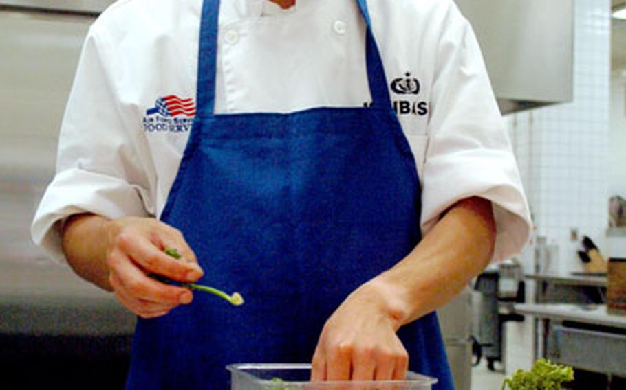 Tomohiro Ishibashi adds garnish to food while setting up for dinner at the Samurai Cafe.
