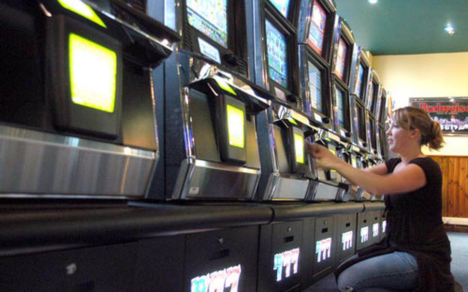 Maggie Bigelow, who works for U.S. Air Forces in Europe Services, labels a new coinless slot machine recently installed at RAF Mildenhall’s Galaxy Club.