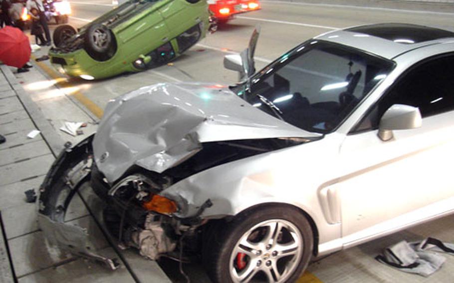 A gray car sits heavily damaged after getting into an accident with the overturned green car in a North Pohang tunnel on Nov. 4. Marine Capt. John Graham and Cpl. Joshua Frazier administered first aid to seven South Koreans at the scene.