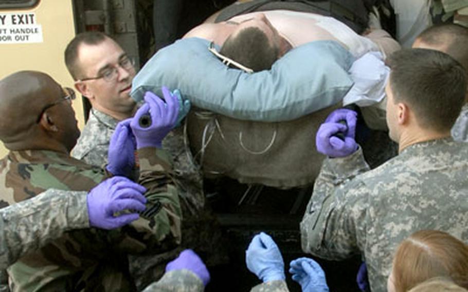 Volunteers from the Army and Air Force help unload a bus carrying wounded just in from Iraq on Thursday at Landstuhl Regional Medical Center.