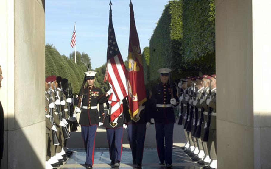 A U.S. Marine Corps color guard marches through a Tunisia color guard during a delayed Veterans Day observance Friday at the North African American Cemetery in Carthage, Tunisia.