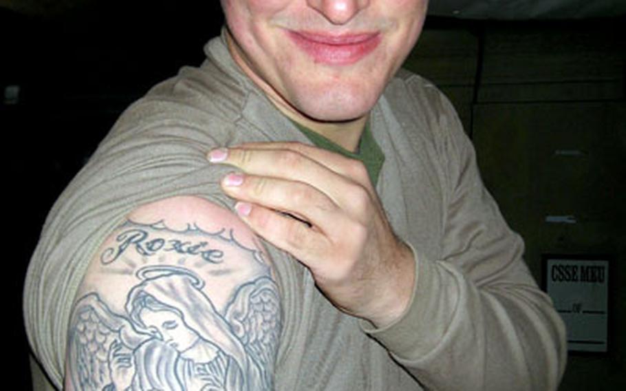 Cpl. Damon Mulazzi shows off a tattoo he designed to honor his late mother, Phyliss “Roxie” Mulazzi, who taught him unrestrained generosity. Mulazzi, known as the “Don” on his base in Iraq, uses that generosity to get troops whatever they need.