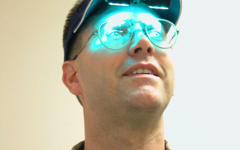 Master Sgt. John West of RAF Lakenheath’s 48th Medical Operations Squadron demonstrates how the soft green, mobile therapy lights are used on patients suffering from Seasonal Affective Disorder.