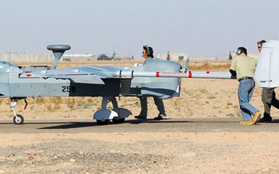 A Hunter UAV maintenance crew wheels the surveillance aircraft off a runway at Contingency Operating Base Speicher, near Tikrit, Iraq, recently.