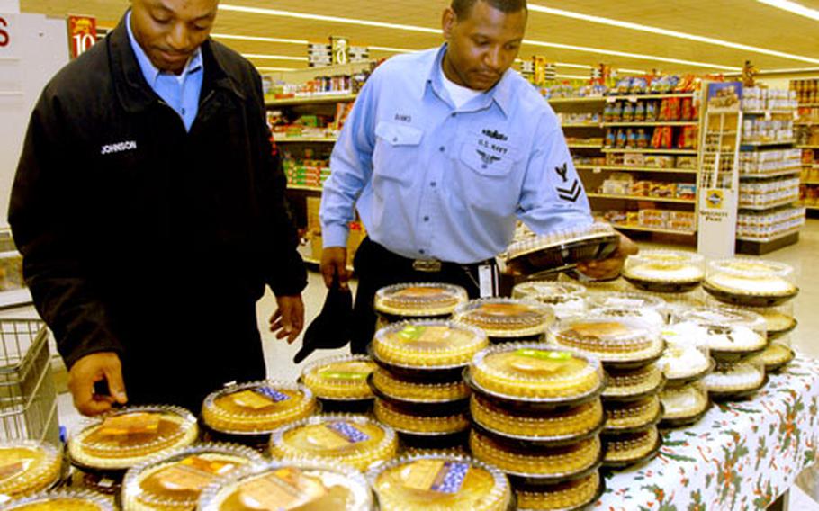 Petty Officer 1st Class Martiz Johnson and Petty Officer 2nd Class Dayon Banks peruse the pie display at the commissary on Yokosuka Naval Base, Japan, on Tuesday. If last year's numbers are any indication, the commissary will sell almost 600 pumpkin pies for Thanksgiving.