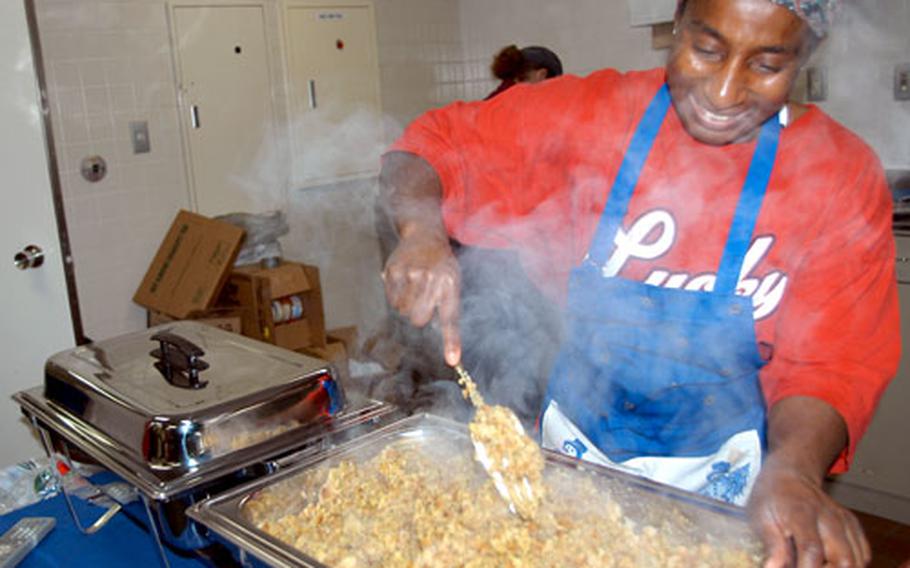 Senior Master Sgt. Tina Heggins of the 301st Intelligence Squadron is still smiling while mixing the stuffing, even after a day spent filling 12 dozen deviled eggs and performing other chef duties for Security Hill’s annual Thanksgiving dorm feed.