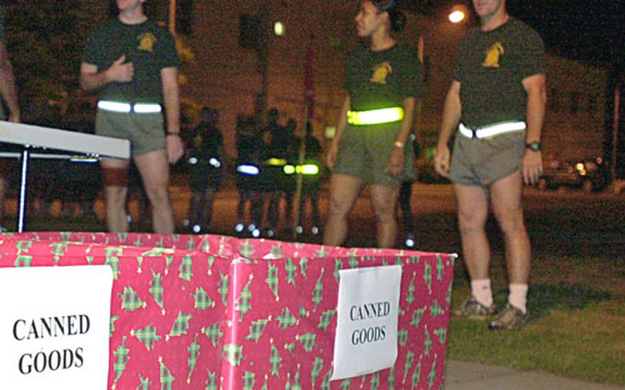 Instructors and students at the Staff NCO Academy gather in the parking lot before the start of a director's run on Monday. This run was a little different: Students who donated canned goods had an easier run in return. The collected food was delivered to chaplains Tuesday for distribution.