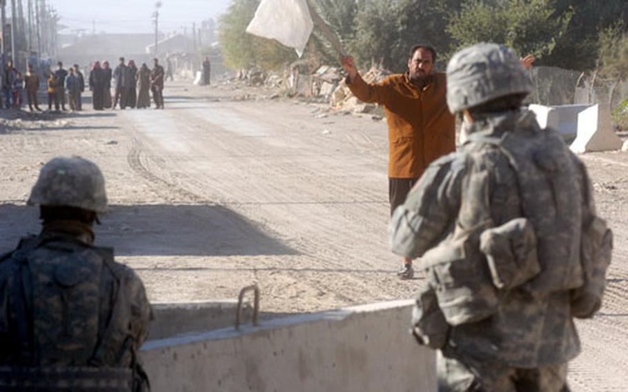 A man waving a white flag on Wednesday approaches soldiers of the 1st Battalion, 18th Infantry Regiment outside Combat Outpost Steel in Ta’meem, Iraq, a suburb of Ramadi. The man wanted permission to dig a hole so he could fix a broken water pipe. Digging is forbidden in the area because insurgents do it to plant roadside bombs.