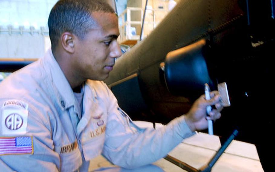 Private First Class Robert Ibrahim, 19, of Cocoa Beach, Fla., prepares a metal patch for a bullet hole in an Apache Longbow attack helicopter. Ibrahim repairs aircraft with the 1st Attack Reconnaisance Battalion of the 82nd Combat Aviation Brigade, which is currently attached to the 25th Infantry Division's Combat Aviation Brigade.