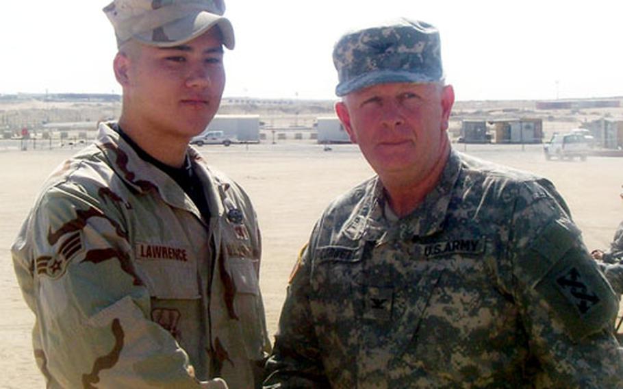 Senior Airman Michael Lawrence shakes hands with an Army colonel after receiving the Army Combat Action Badge for his actions on a convoy in Iraq.