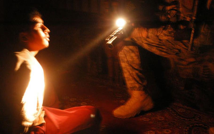 A young man is interrogated by a U.S. soldier during a raid early Sunday morning in Ta’meem, Iraq, a suburb of Ramadi in Anbar province. The soldiers determined that the man wasn’t the one they were looking for and did not detain him.