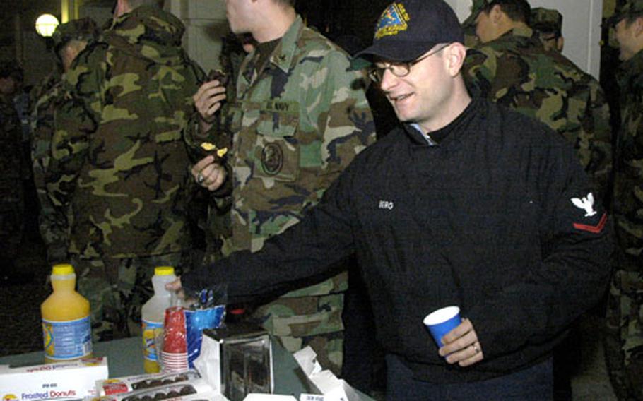 Petty Officer 3rd Class Massimo Berg fills up on free donuts and orange-flavored drink in the pre-dawn hours Tuesday as he prepares to retake a promotion exam.