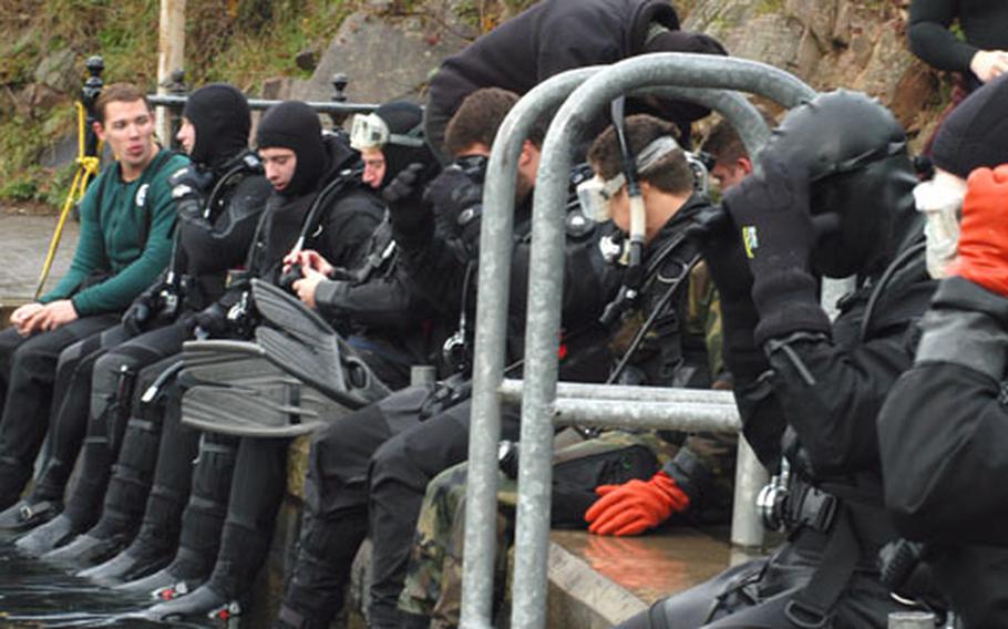 Members of the 352nd Special Operations Group sit on the dock at the Stoney Cove diving center, where the airmen spent the day scuba training. While the members of the 352nd specialize in air operations, they also must maintain skills for land operations. Scuba training could be necessary for search and rescue missions.