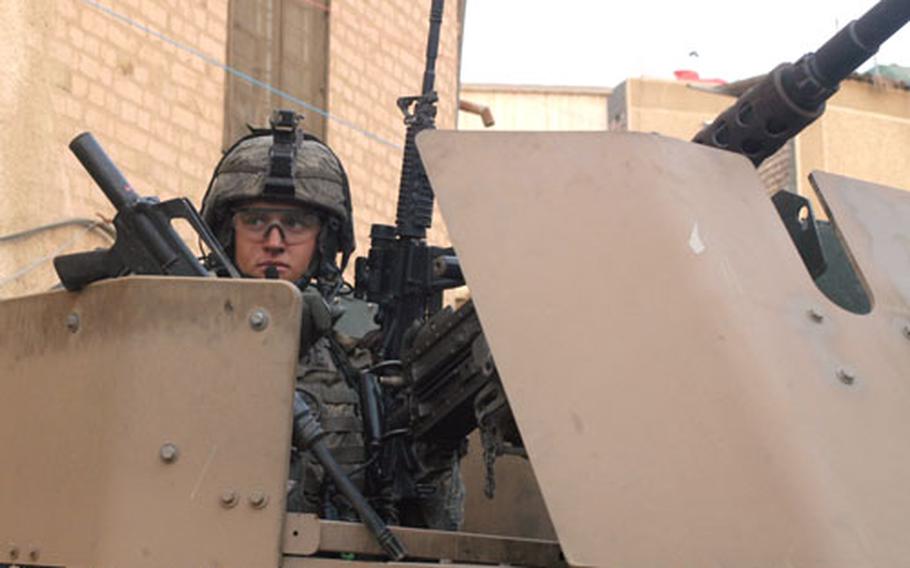 Pfc. Ross McGinnis from 1st Platoon, Company C, 1st Battalion, 26th Infantry Regiment, mans his weapons in the turret of a Humvee in the Adhamiyah neighborhood of Baghdad just days before the violence that followed the Saddam Hussein verdict Nov. 5.