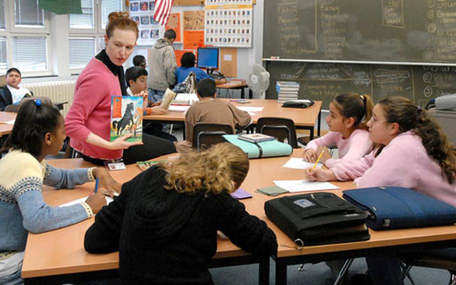 Teacher Liz Walters talks to students in her Darmstadt Middle School reading class about what to read next. DODDS-Europe announced Wednesday that the school will close at the end of the school year and be combined with the elementary school, making it a K-8 school.