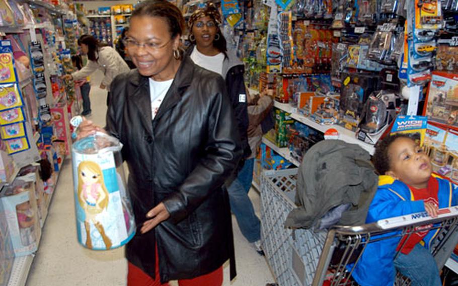 Darlene Kirksey, foreground, and Dana Cooper shop Wednesday at the base exchange at Misawa Air Base, Japan, with Cooper's one-year-old son, Terrance. Military exchanges in the Pacific reported an overall increase of sales during the Thanksgiving holiday weekend from last year.