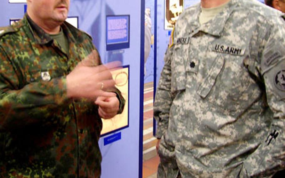 German Maj. Achim Poch, left, 12th Panzer Brigade logistics officer, and Lt. Col. Myron Reineke, 2nd Squadron, 2nd Cavalry (Stryker) Regiment commander, chat Thursday at the opening of an exhibit on German-American friendship in Vilseck, Germany.