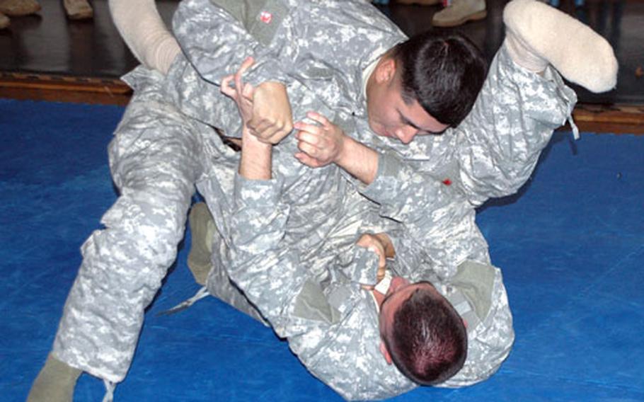 Staff Sgt. Aldebert Concepcion, top, spars with his opponent during combatives training at Camp Zama, Japan.